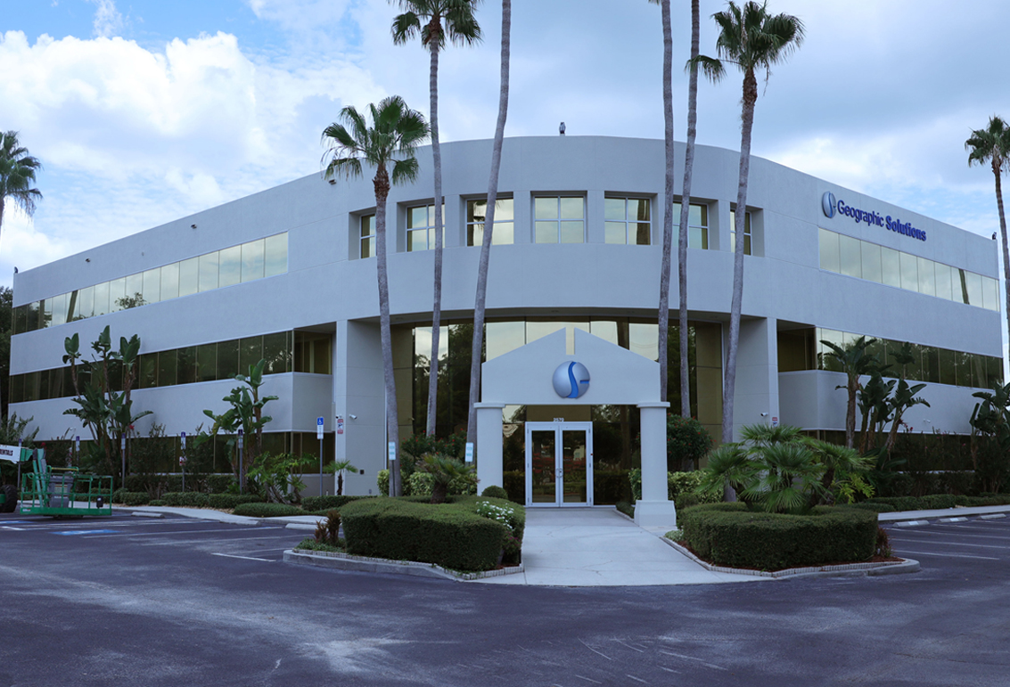 This image is an exterior photograph of a commercial office building located at 2570 Coral Landing Blvd, Palm Harbor Florida